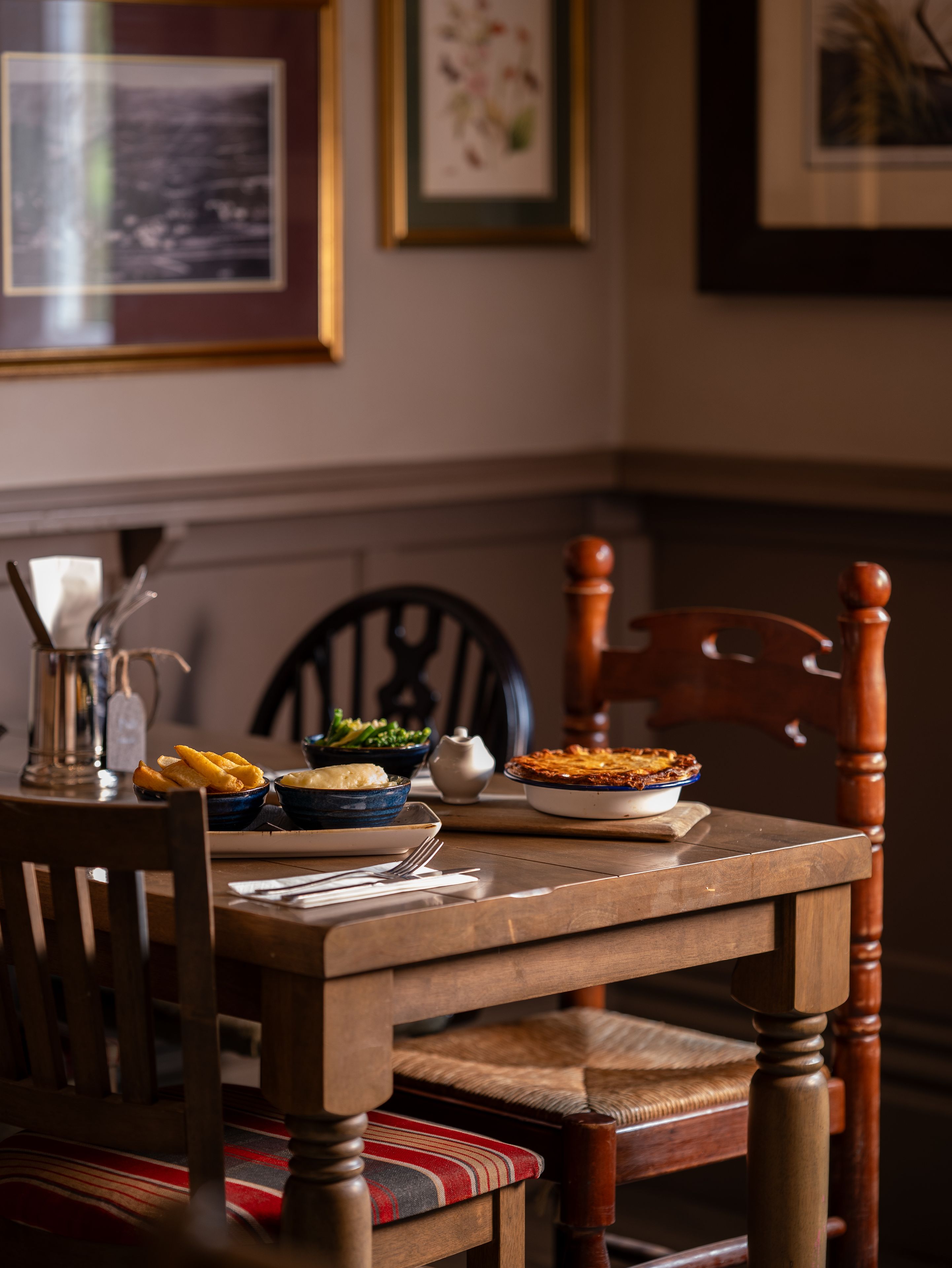 pie, mash, chips and greens at a table in the buck inn restaurant